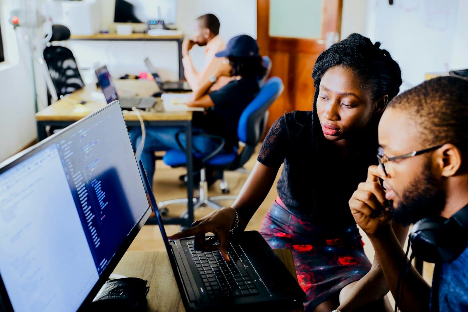 Two people collaborating in front of a laptop screen
